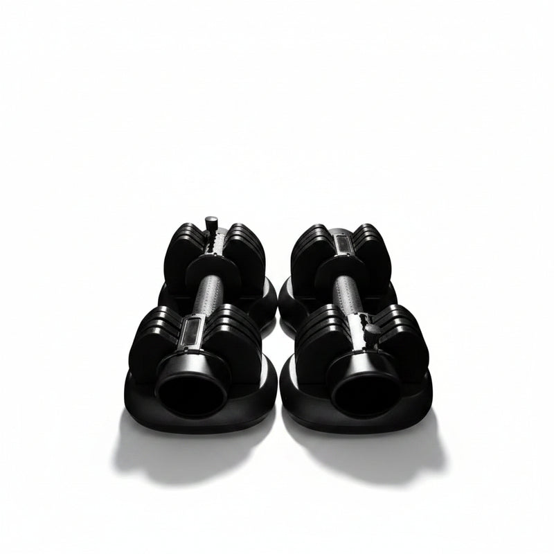 Load image into Gallery viewer, Two black adjustable dumbbells with weight markings, resting on a light gray tiled floor.
